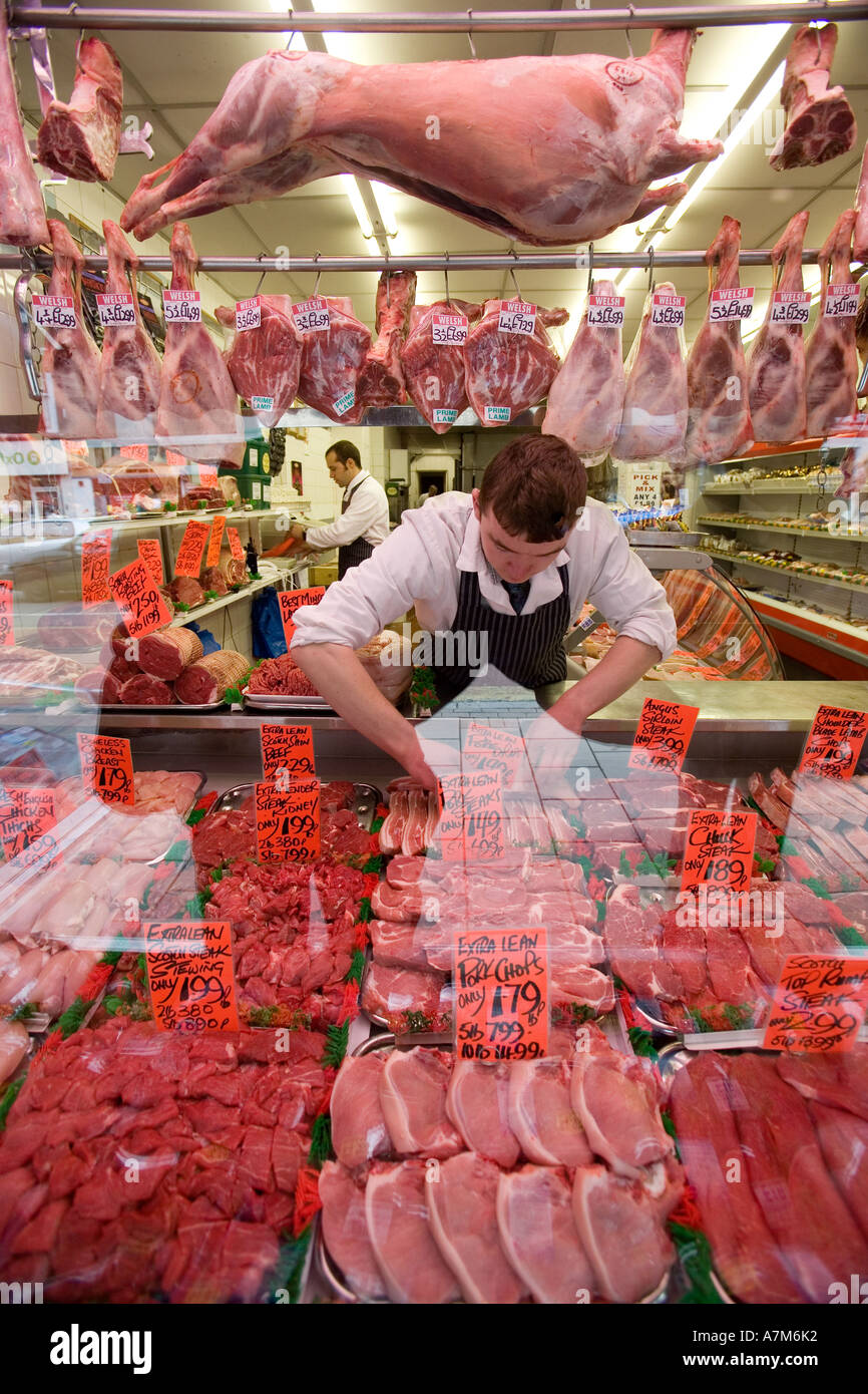 Ein Metzger ordnet eine Anzeige von Fleisch in die Schaufenster in Birmingham UK Stockfoto