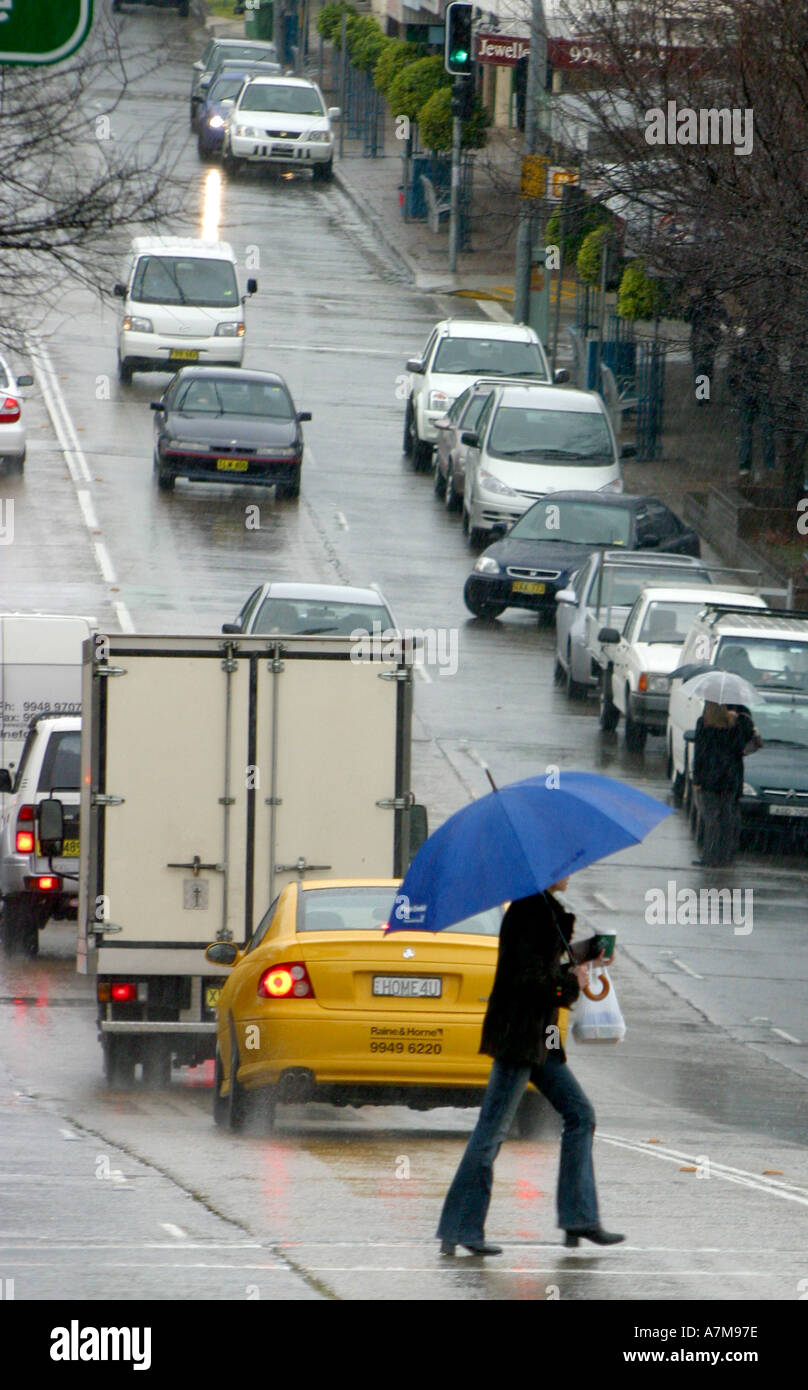 Fußgänger überquert Straße bei nassem Wetter Stockfoto