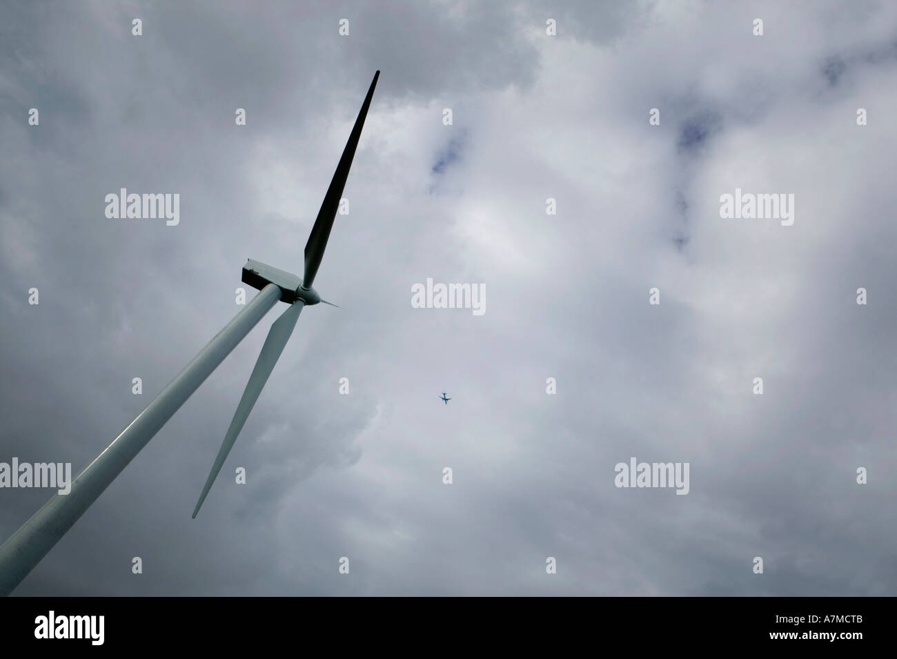Windturbine und Flugzeug fliegen in Ferne Stockfoto