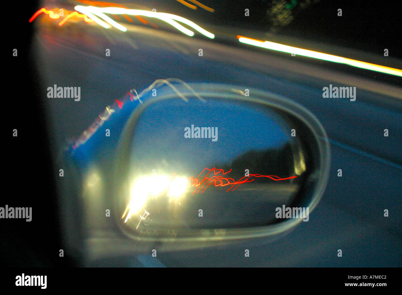 Nähert sich der Verkehr in Außenspiegel des Autos auf der Autobahn bei Nacht angesehen Stockfoto