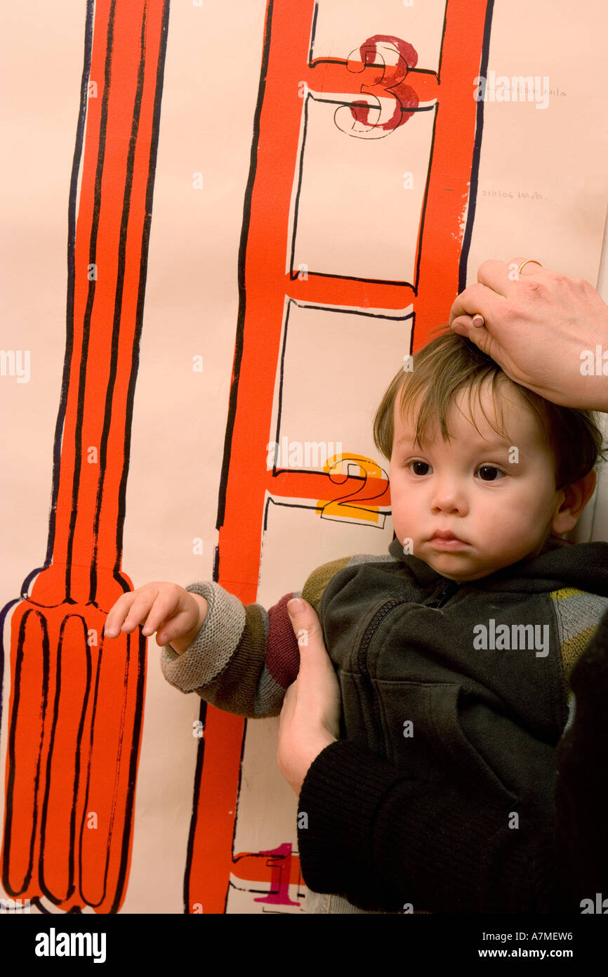 Baby Boy auf Höhe Chart gemessen wird Stockfoto