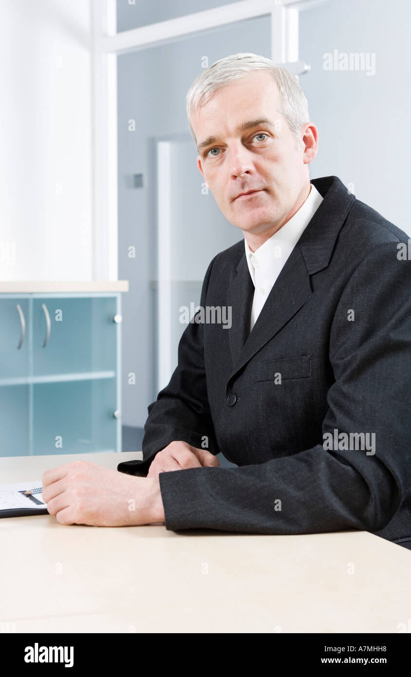 Ein reifer Geschäftsmann sitzt in einem Konferenzraum Stockfoto