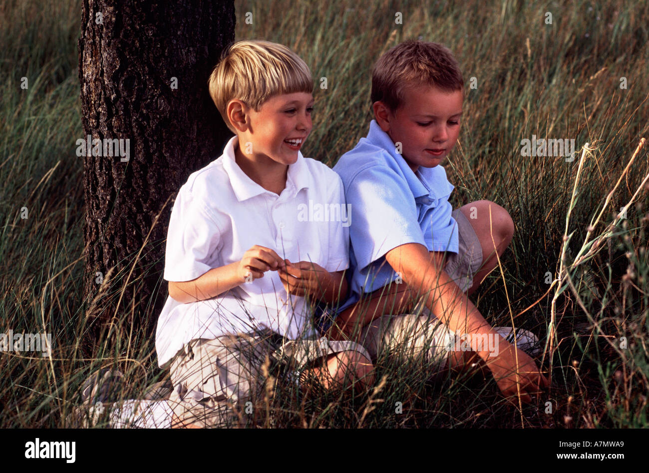 Zwei Jungs auf einer Wiese sitzen. Sunriver, Oregon (MR) Stockfoto