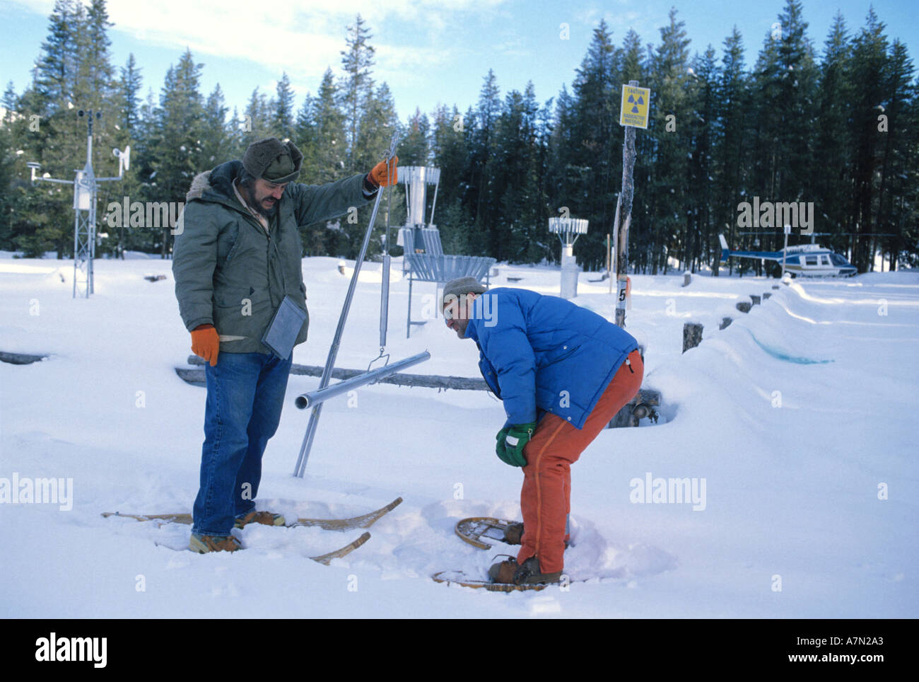 Männer gekleidet in warme Kleidung arbeiten unter extremen Bedingungen auf einer Umfrage bei Schnee Wassergehalt bestimmen Stockfoto