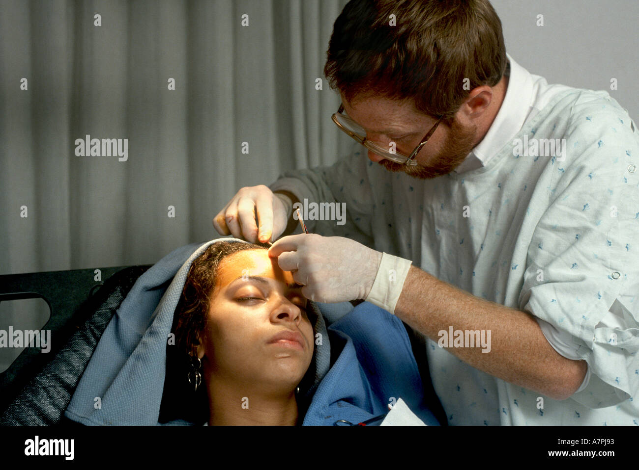 Ein platic Chirurg Stiche s Kopf einer Frau in die Notaufnahme Stockfoto