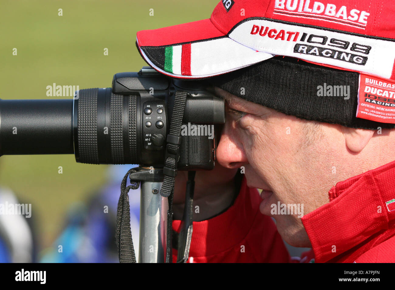 Mann mit modernen kompakte Bridge-Kamera mit sehr langen Zoom auf ein Einbeinstativ unterstützt. Stockfoto