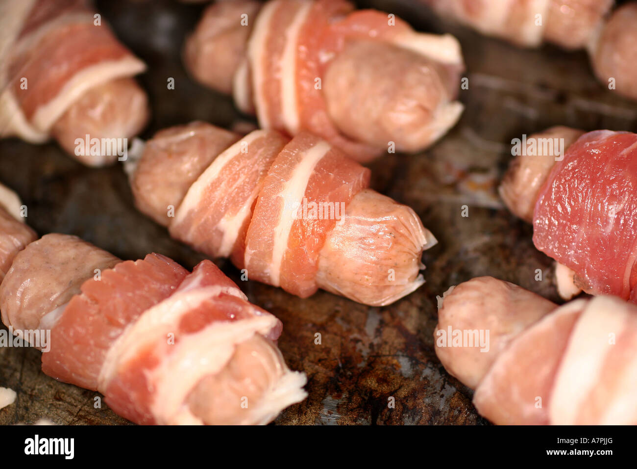 Kleine cocktail-Würstchen mit Speck umwickelt auf einem Tablett bereit für das Kochen. Stockfoto