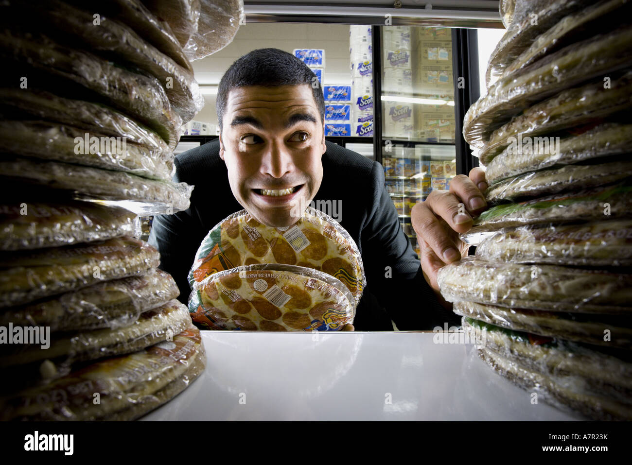 Mann hält Pizza im Supermarkt Stockfoto