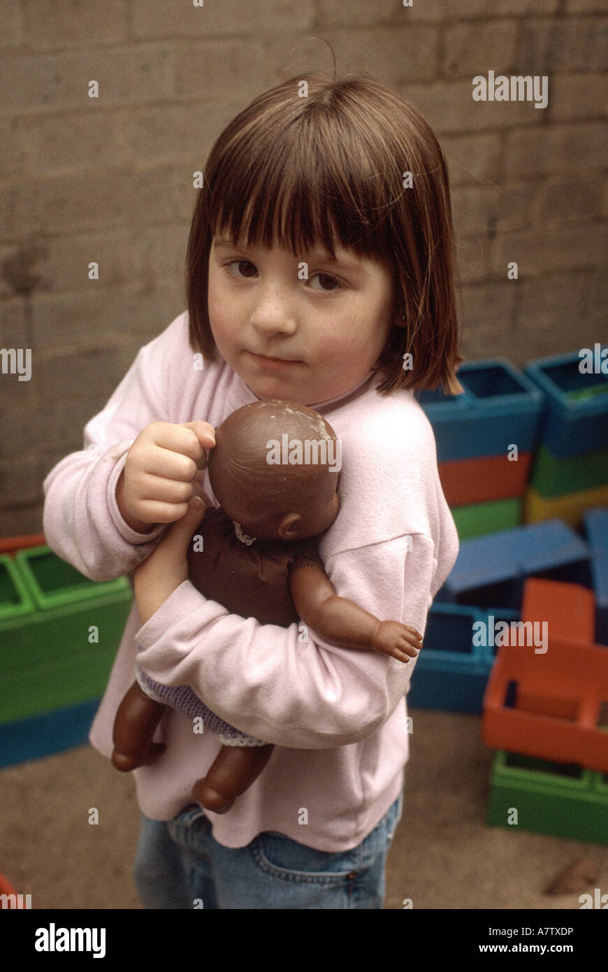 jungen Kinderzimmer Mädchen halten schwarze Puppe Stockfoto