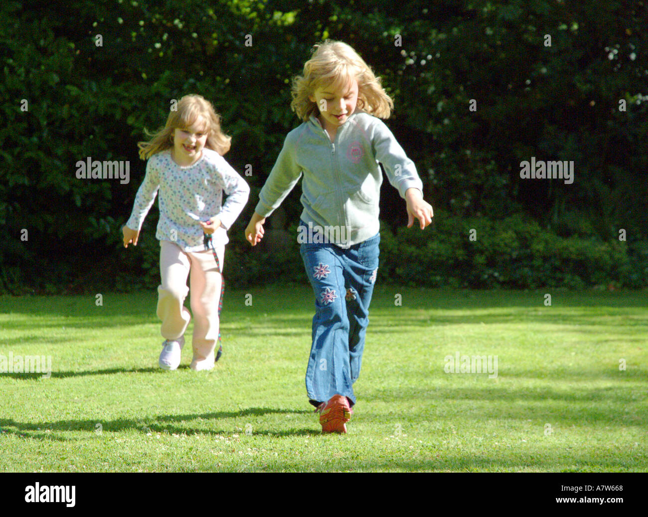 Junge Mädchen laufen auf dem Rasen Stockfoto
