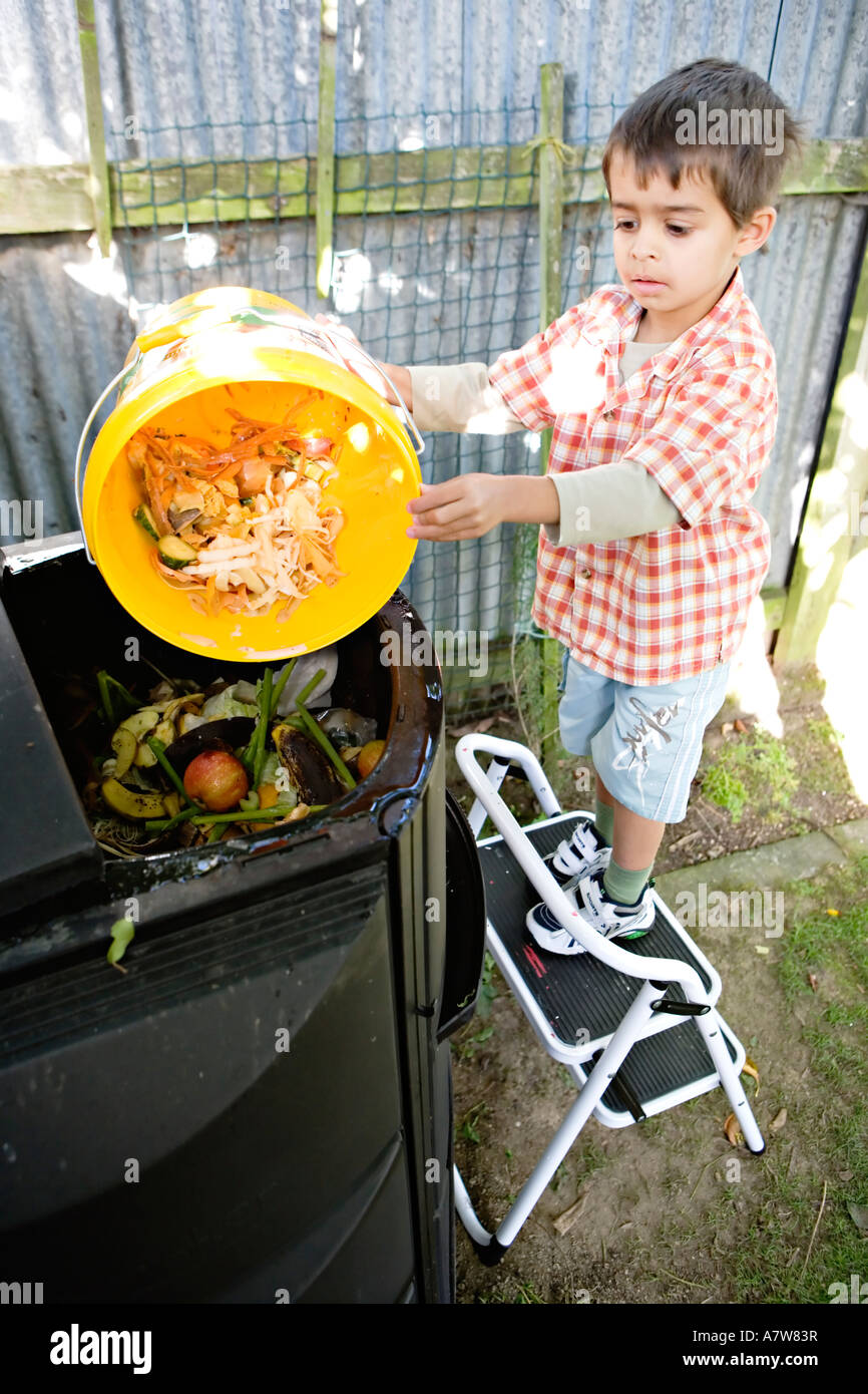 Kind stellt Küchenabfälle in eine Biotonne Stockfoto