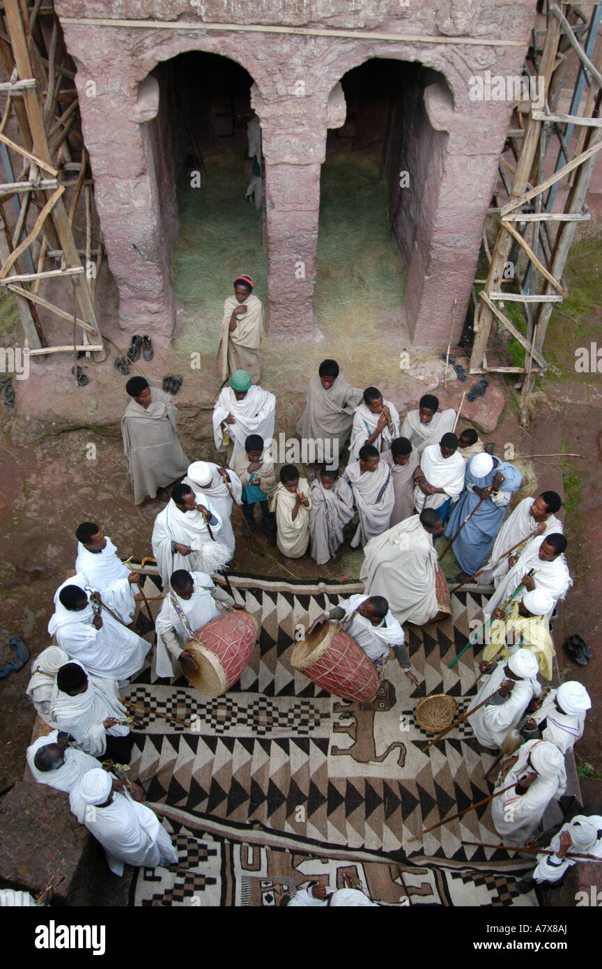 Äthiopien: Lalibela, koptischen christlichen Mönche außerhalb Kirche singen mit jungen Trommler auf lokal hergestellte braun, Stockfoto