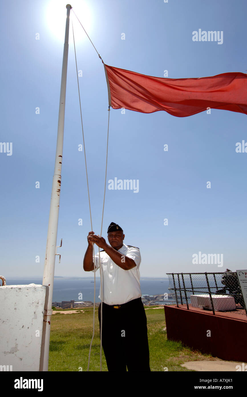 Chief Petty Officer Dudley Malgas wirft die rote Flagge vor der Bewaffnung der Mittag-Pistole in Kapstadt, Südafrika. Stockfoto