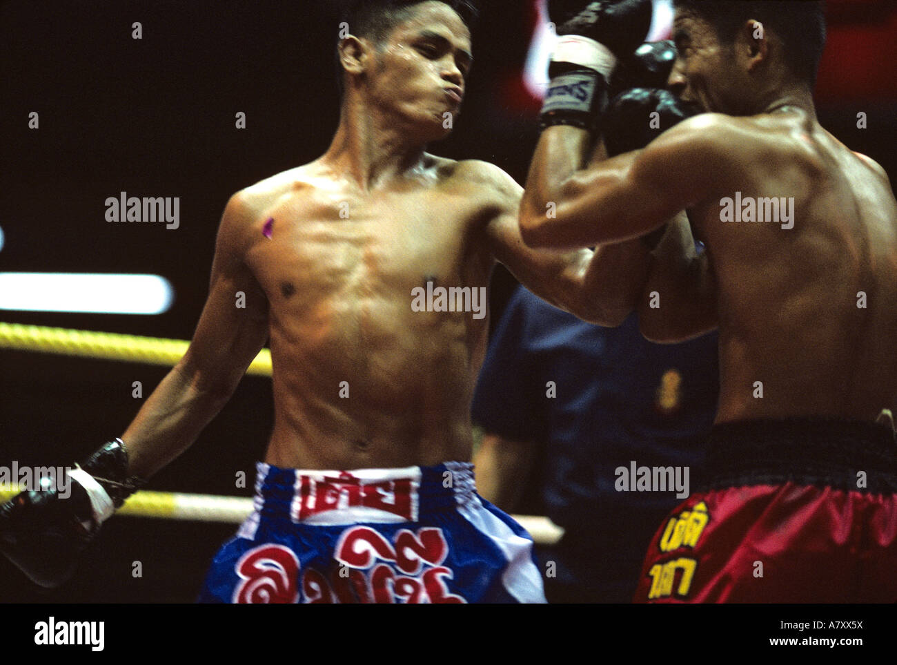 Südost-Asien, Thailand, Bangkok, Schweiß getränkt Kämpfer liefert Schlag während Kick Boxkampf (Muay Thai) Stockfoto