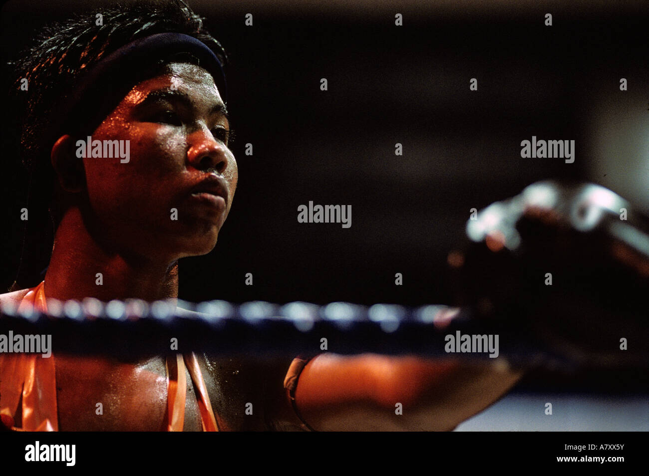 Südost-Asien, Thailand, Bangkok, Schweiß getränkt Kämpfer steht entlang Seile zwischen den Runden des Wettbewerbs Kickboxen (Muay Thai) Stockfoto