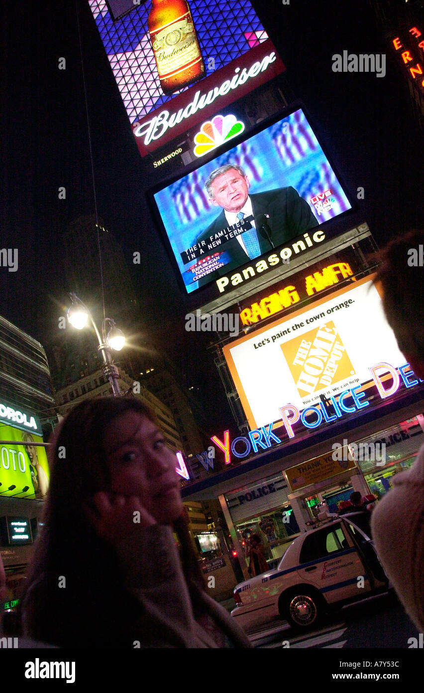 Besucher zum Times Square zu sehen die Ernennung von Präsident George w. Bush auf Großbildschirmen Stockfoto