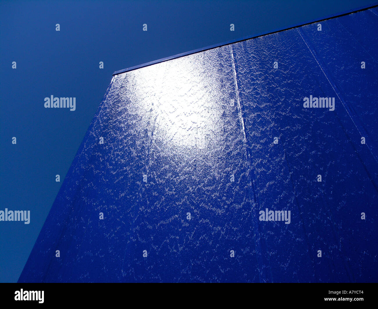 Wasser an der Oberfläche des Gebäudes in blau lackierten Metallplatten abgedeckt Stockfoto