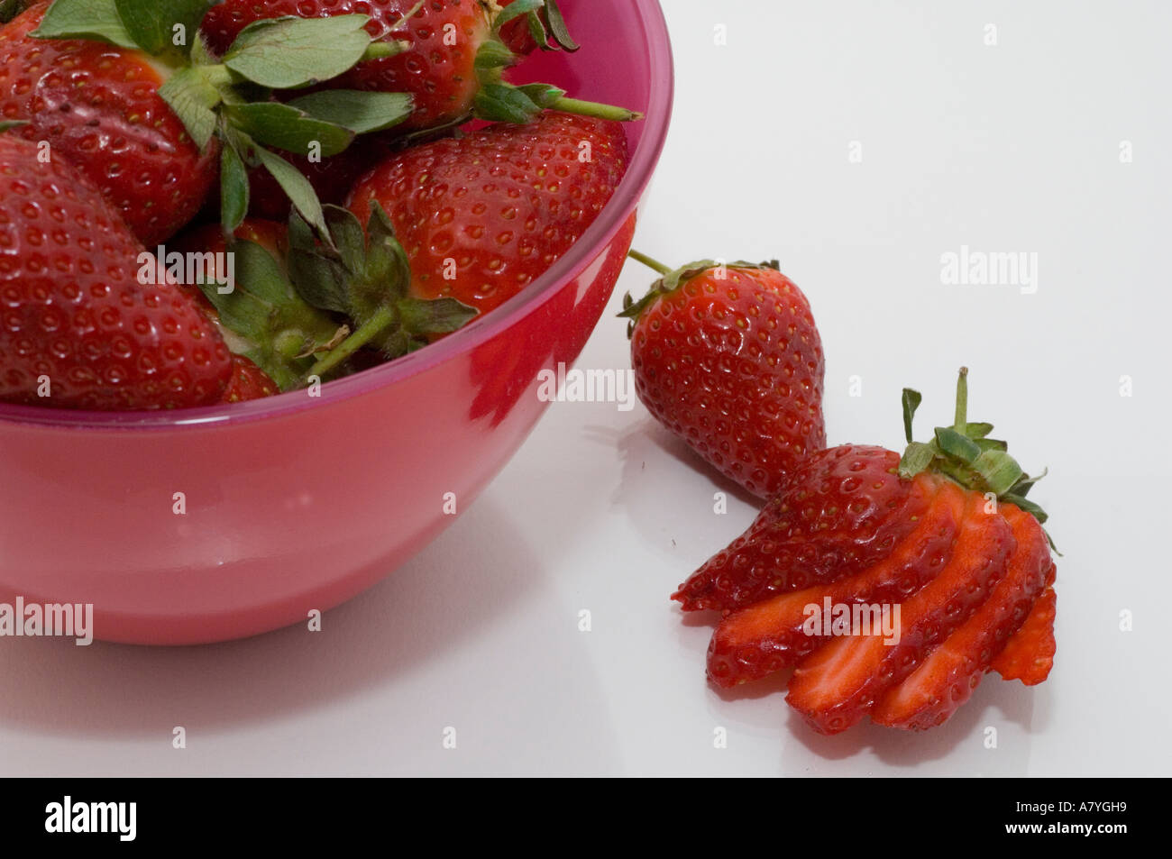 Erdbeeren in eine rosa Glasschüssel auf weißem Hintergrund Stockfoto