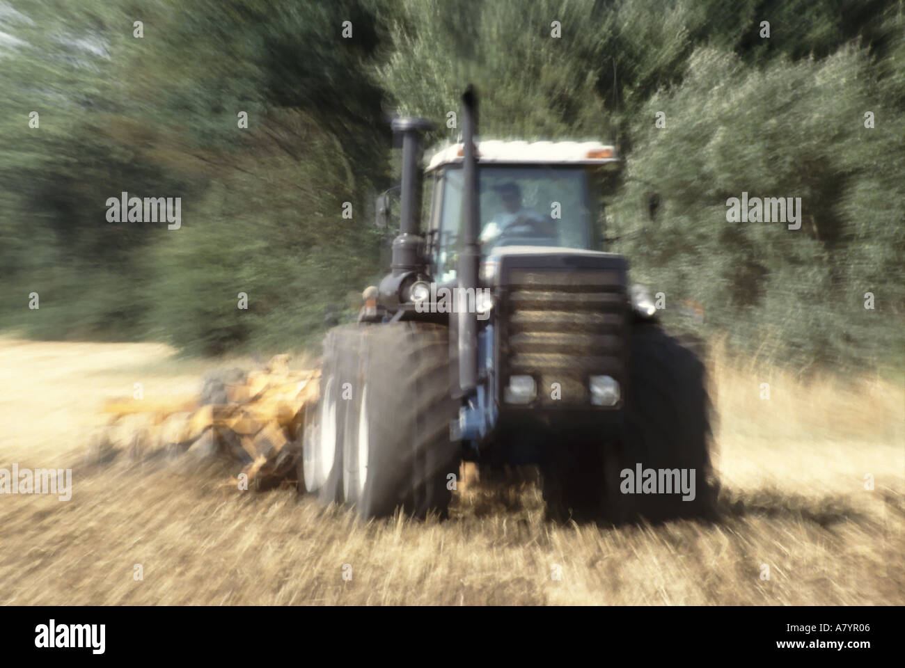 Traktor Abschleppen Ausrüstung Stoppelfeld vorbereiten neue Jahreszeiten Aussaat Linse vergrößert während der Belichtung, Motion-Effekt zu geben Stockfoto