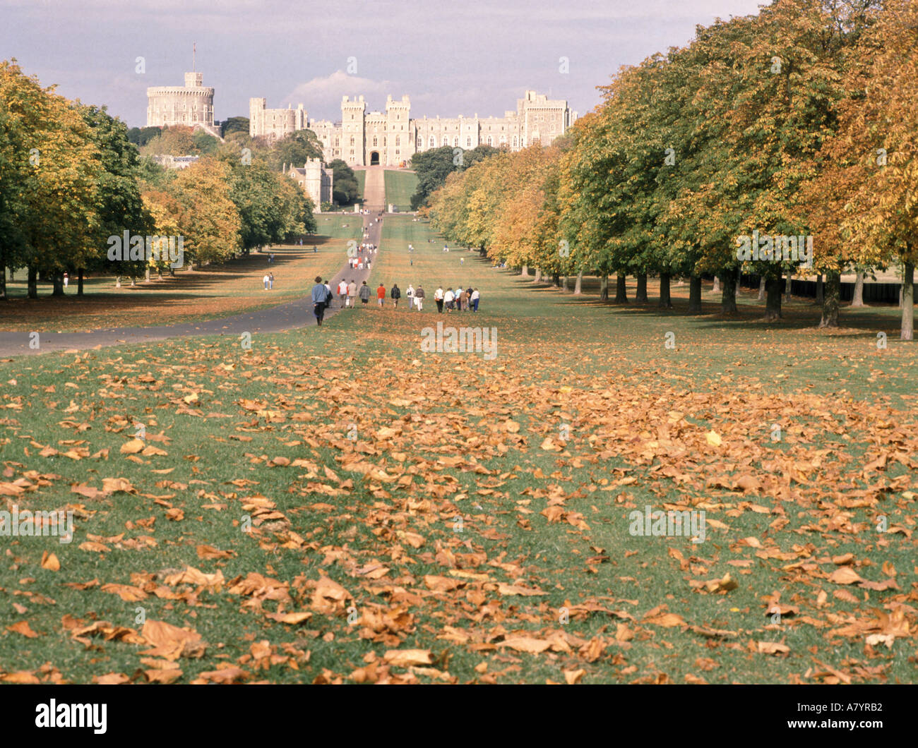 Menschen, die im Royal Park spazieren gehen lange Wanderung zwischen Herbstbäumen und Herbstlaub im Windsor Great Park mit Schloss jenseits von Berkshire England Stockfoto