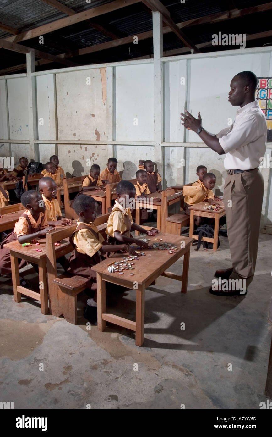 Innerhalb Klassenzimmer von gemischten Gruppe von jungen Mädchen und Jungen Junior-Schule Kinder in Mathe-Klasse, mit Flaschentops als Zähler, in Ghana, Westafrika Stockfoto