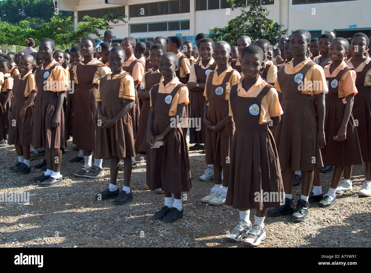 Gemischte Gruppe von jungen Mädchen Schulkinder aufgereiht für die Montage außerhalb Schulgebäude - vor Klassen in Ghana, Westafrika Stockfoto