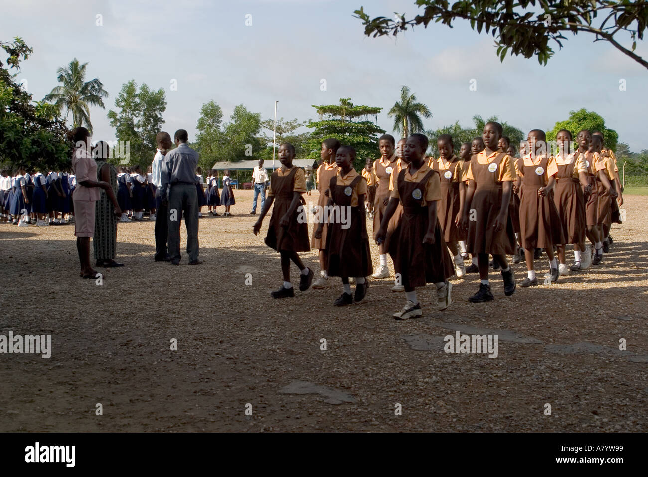Gruppe von Mädchen der Mittelschule in Uniformen verlassen Schulversammlung im Freien gehalten, für Klassenzimmer und vor dem Unterricht in Ghana Westafrika Stockfoto