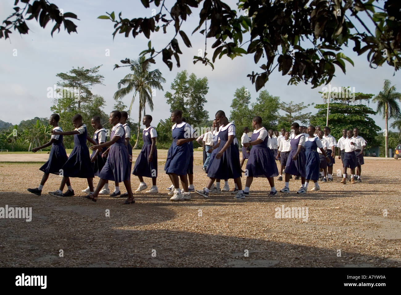 Gemischte Gruppe von älteren Schulmädchen und Jungen Studenten außerhalb marschieren in Versammlung vor Klassen in Ghana, Westafrika Stockfoto