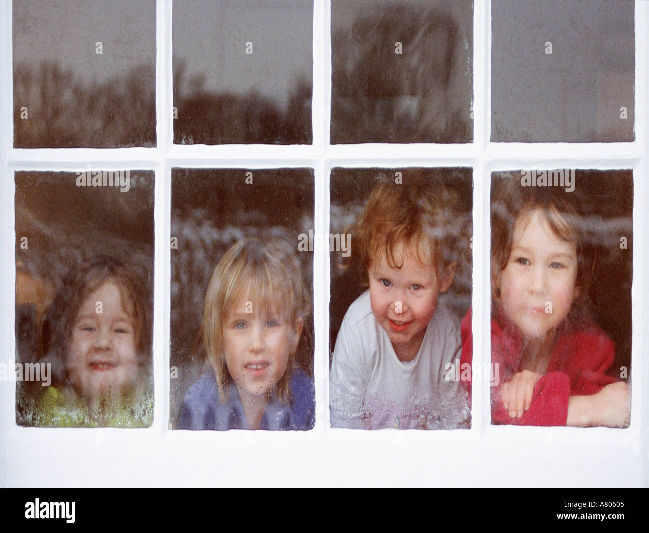 Vier Gesichter hinter Fenster Stockfoto