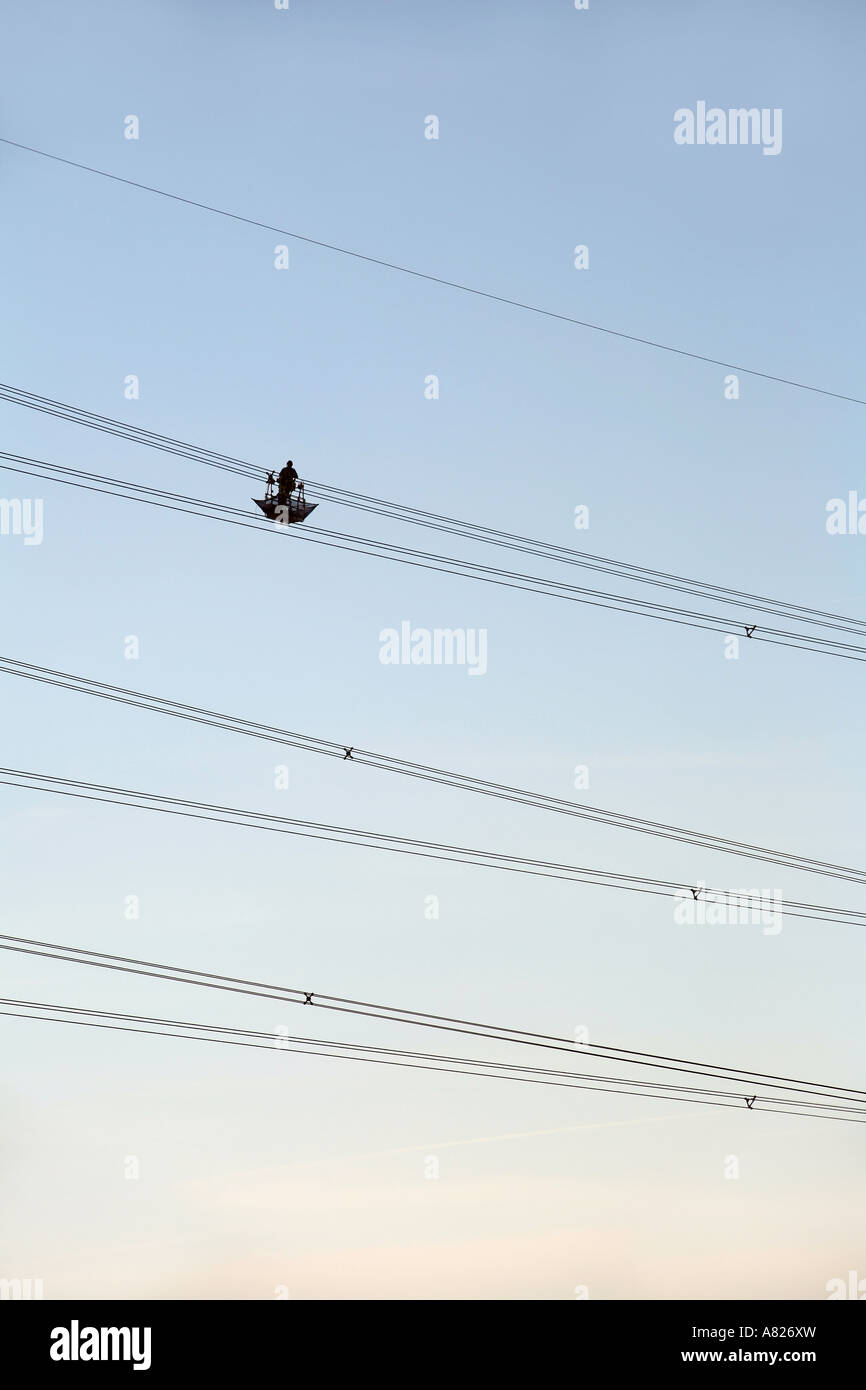 Ein Arbeiter in der Luft schweben untersucht ein Netzkabel, Cambridgeshire, England Stockfoto
