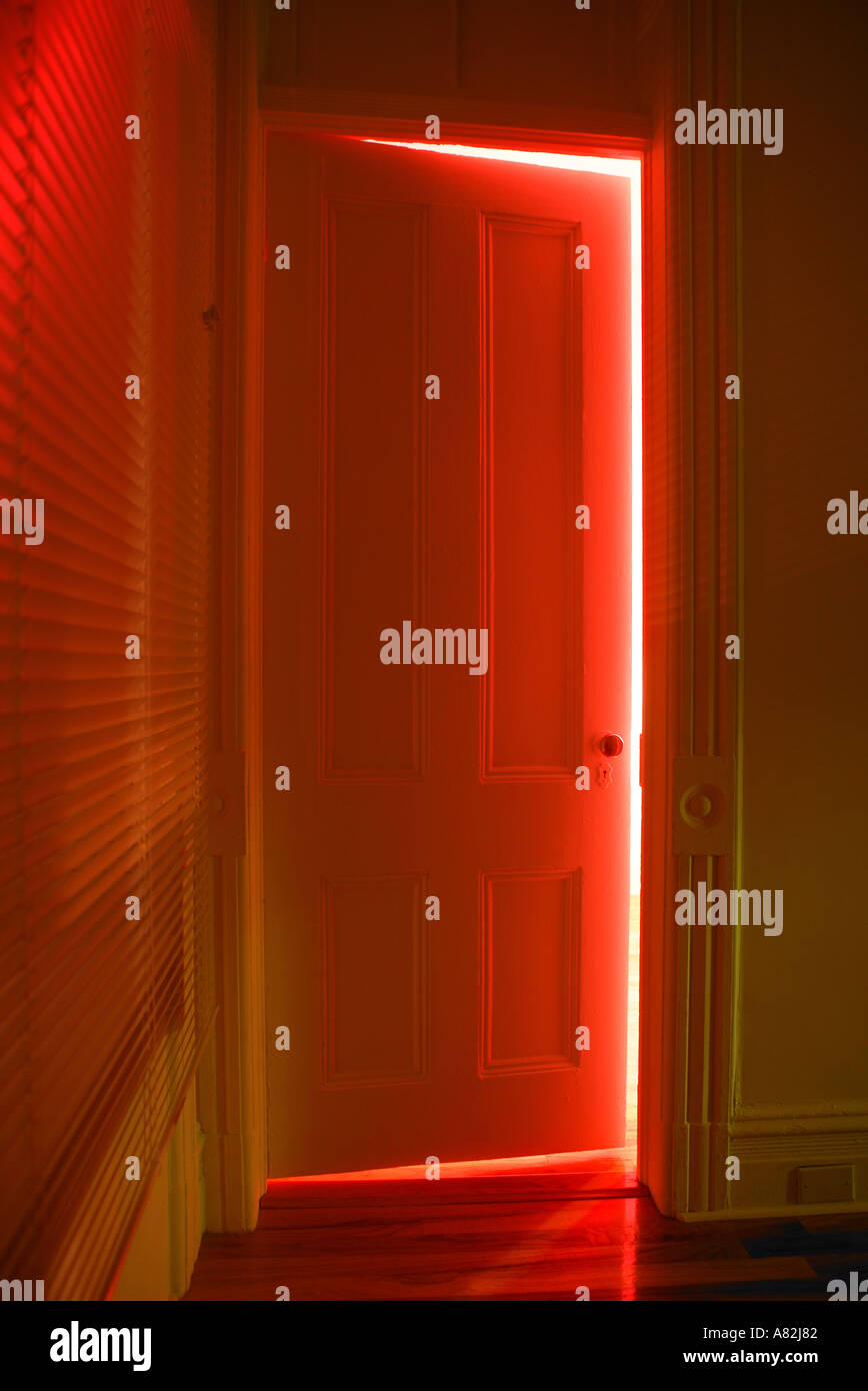 Rotes Licht durch halb offene Tür Stockfoto