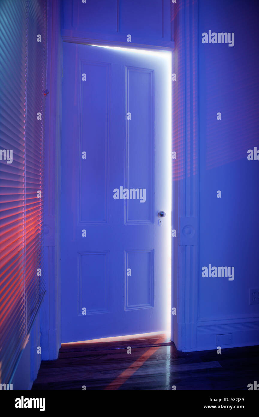 Blaues Licht durch halb offene Tür Stockfoto