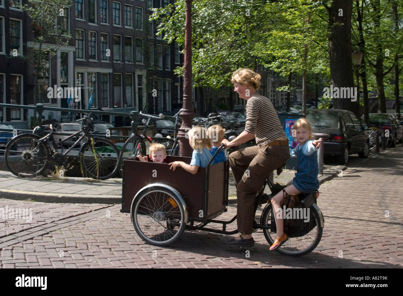 Amsterdam-Mutter mit Kindern auf dem Fahrrad mit Beiwagen Stockfoto