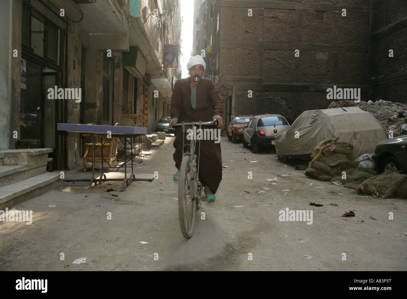 Street Scene mit Mann in traditioneller Kleidung Radfahren und Rauchen Zigarette, Kairo, Ägypten, Naher Osten Stockfoto
