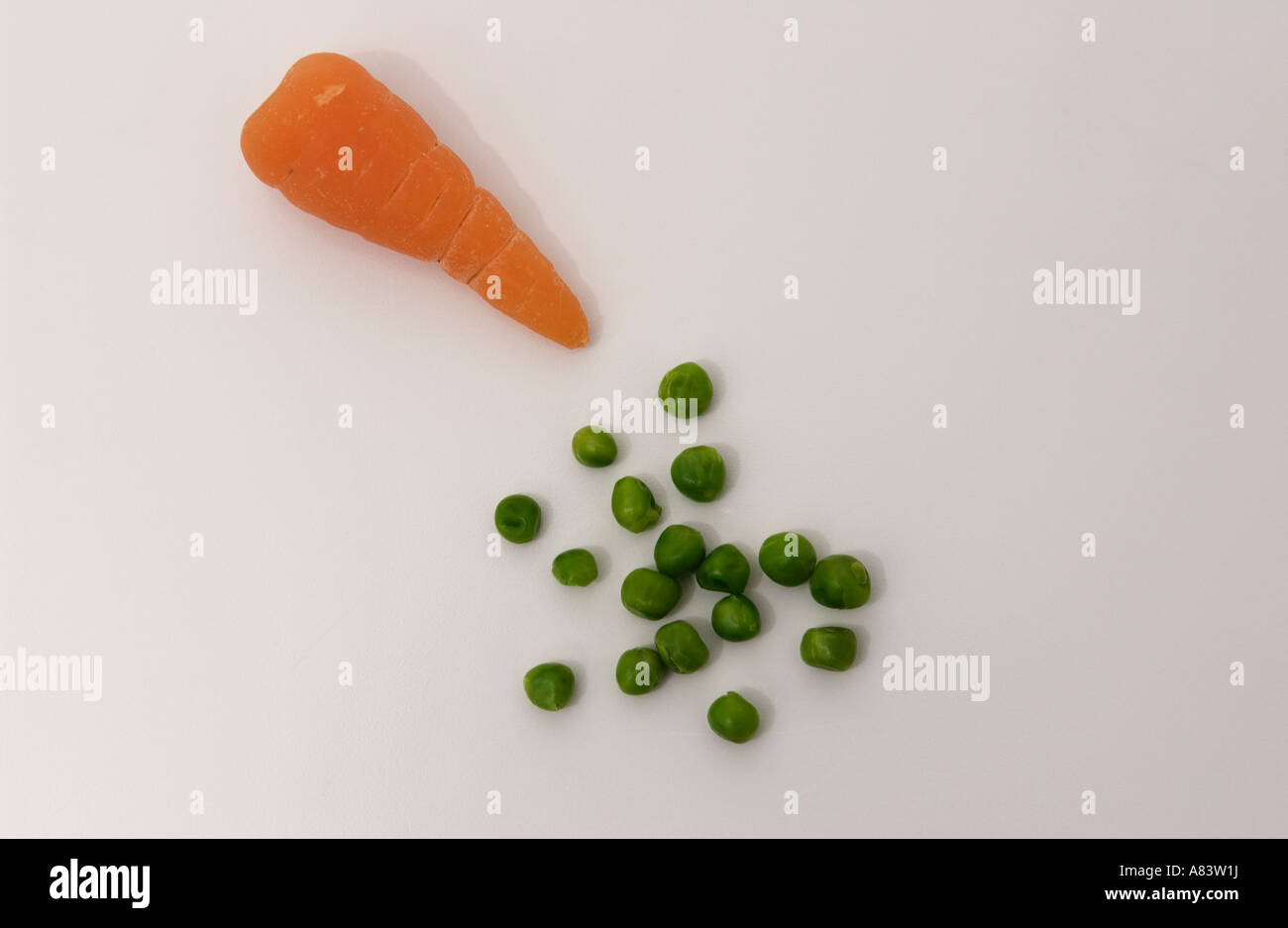 Erbsen und Karotten auf weißem Hintergrund Stockfoto