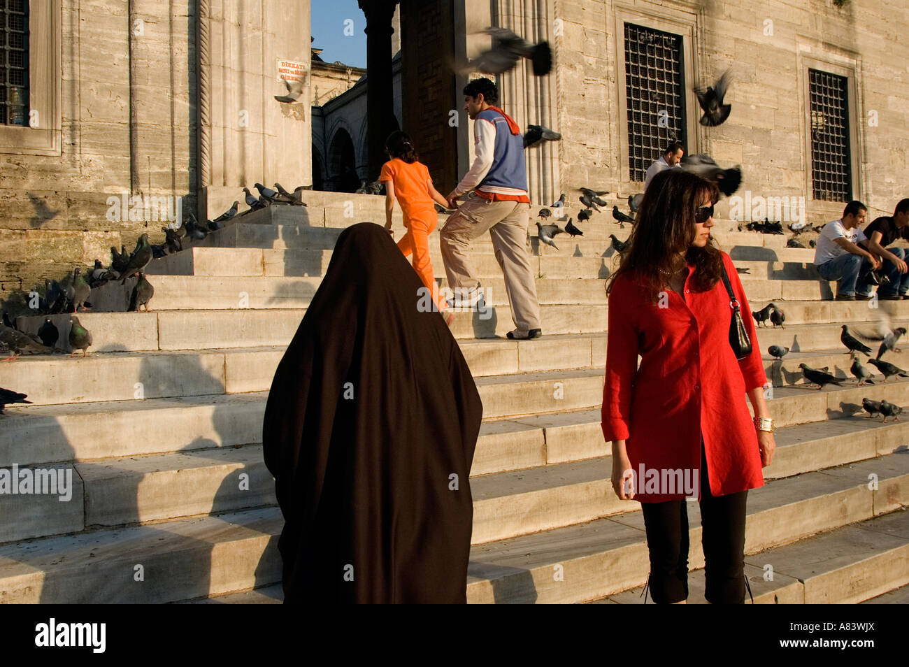 Moderne im Vergleich zu islamischen gekleideten Frauen in Yenicami Moschee, Istanbul-Türkei. Stockfoto