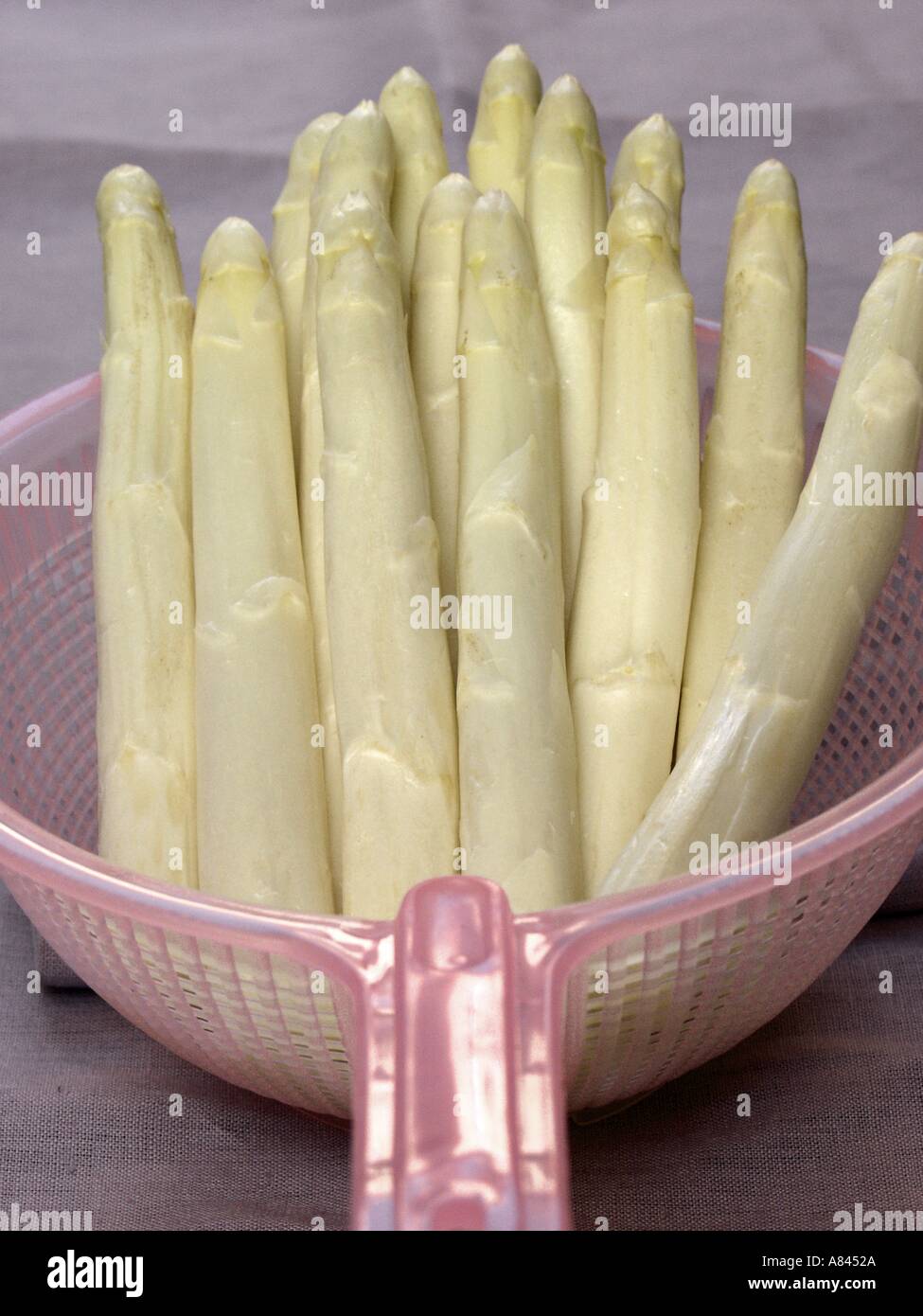 Weißer Spargel in einem rosa Sieb Stockfoto