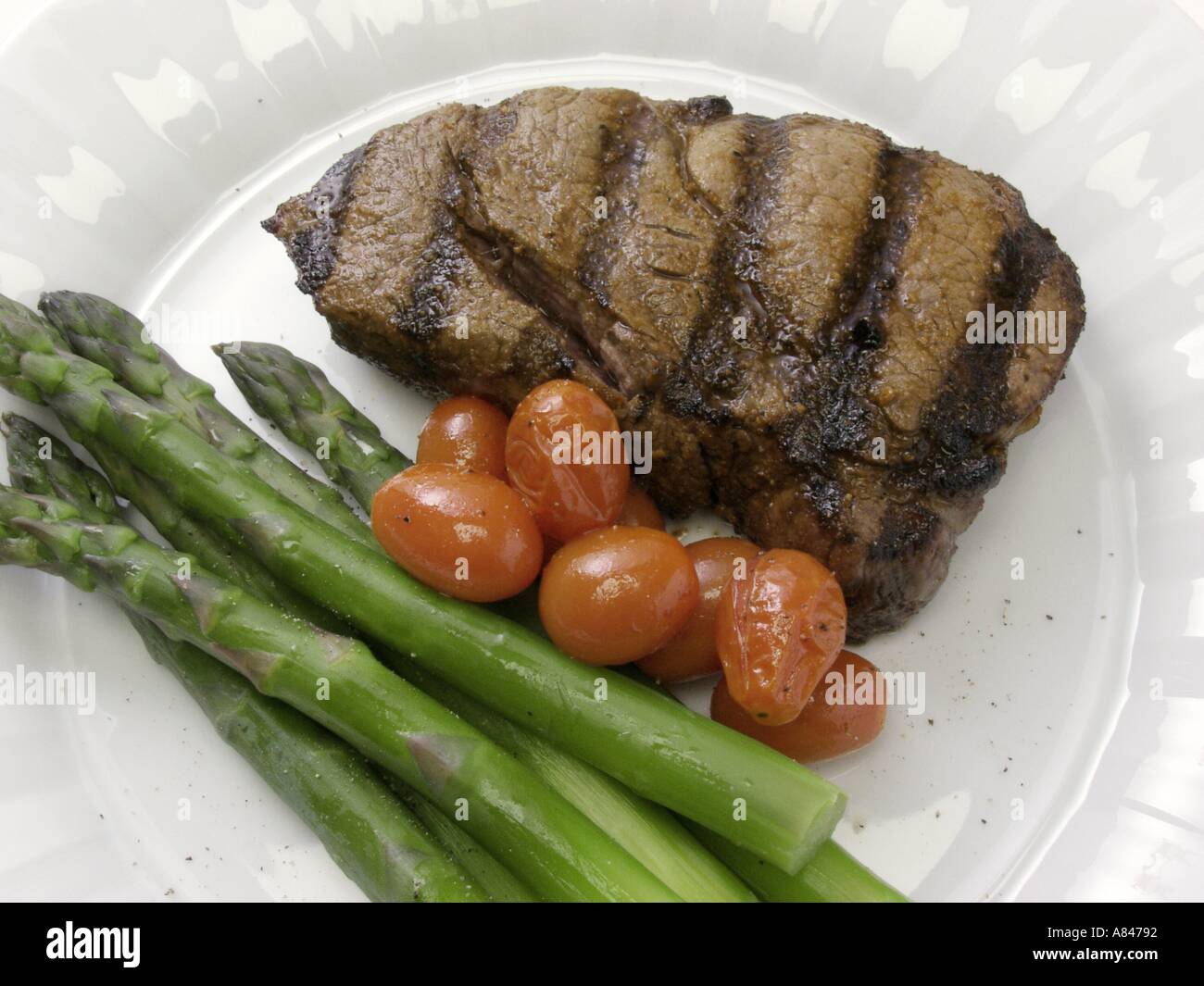 Rib-Eye Steak mit Spargel und Kirschtomaten Stockfoto