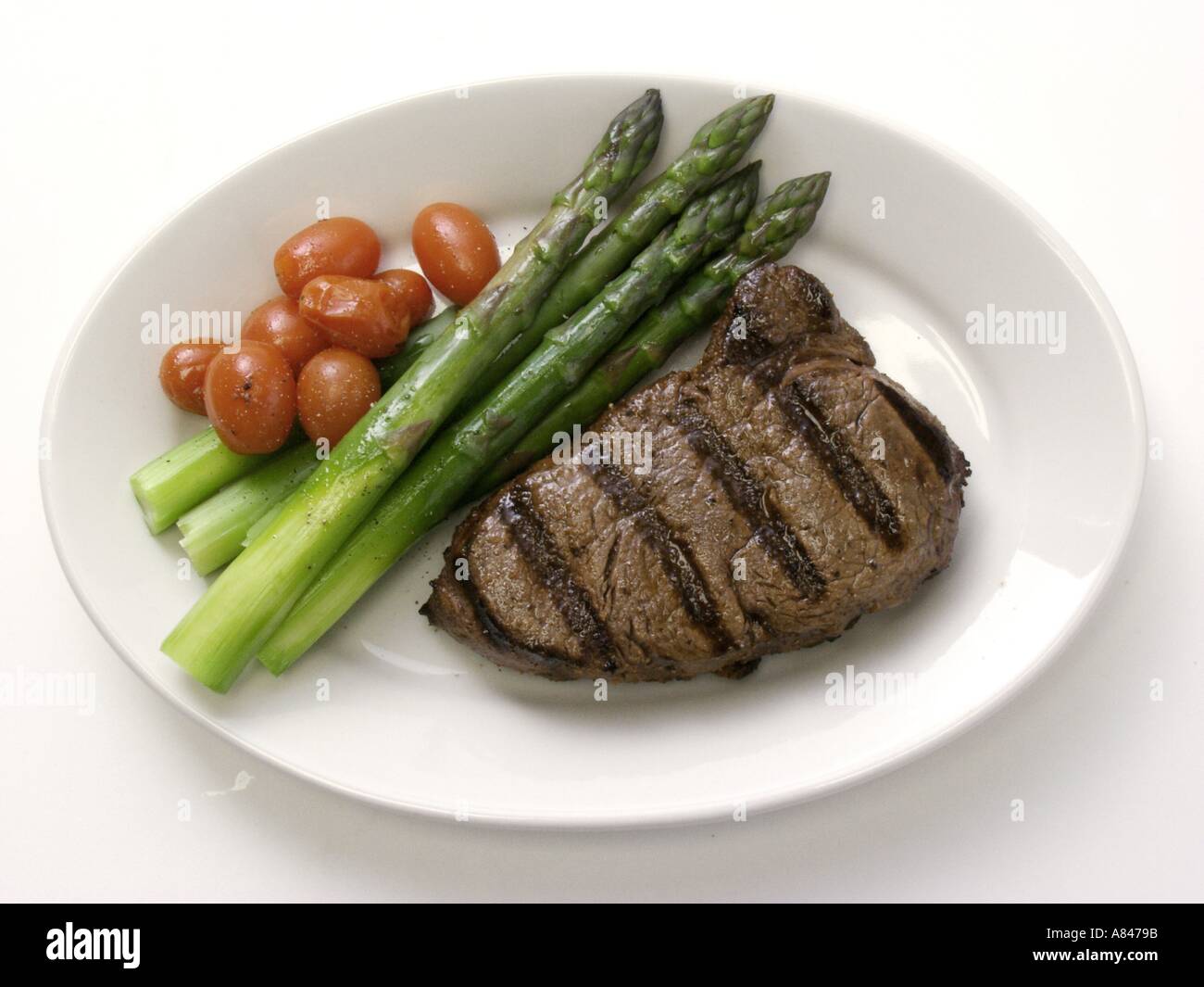 Rib-Eye Steak mit Spargel und Kirschtomaten Stockfoto