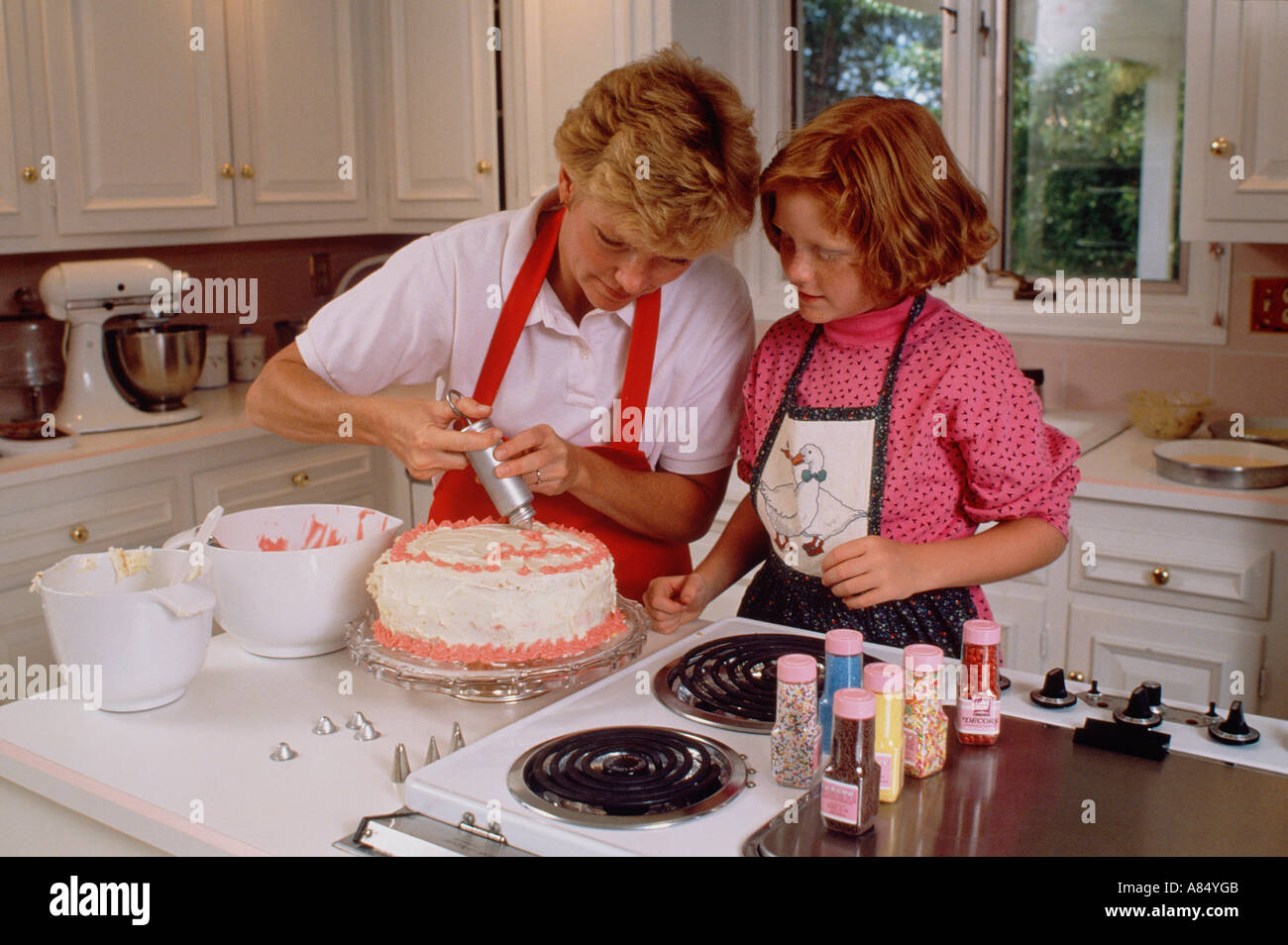 Familie. Mutter und Tochter im Haus in der Küche einen Kuchen Glasur. Stockfoto