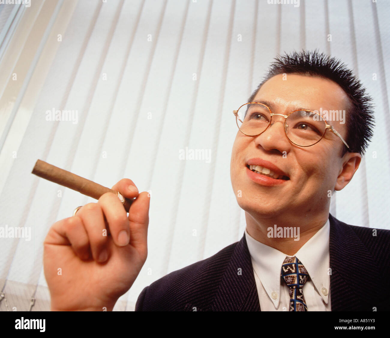 Porträt von wohlhabenden jungen Chinageschäft Mann Rauchen Zigarre. Stockfoto