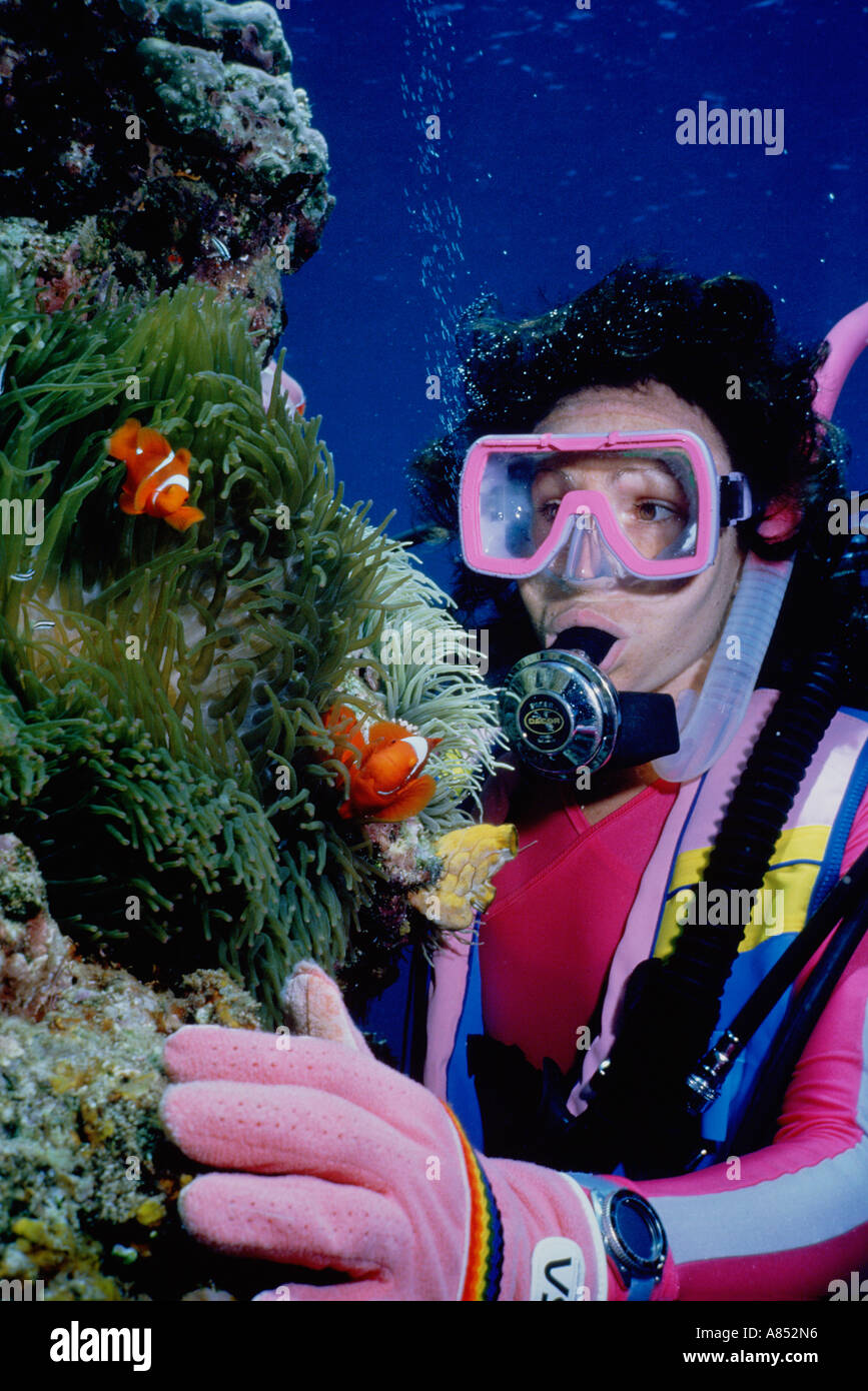 Australien. Scuba Diving. Frau Taucher Unterwasser beobachten Clownfisch. Stockfoto