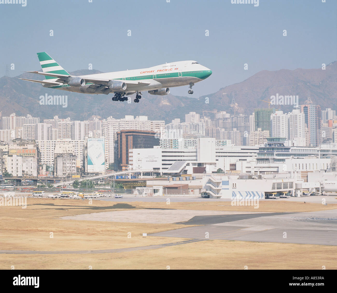 China. Hong Kong. Historische Aufnahme (ca. 1985) von Boeing 747 Jumbo Jet landet auf dem Flughafen Kaitak im Zentrum Stadt. Stockfoto