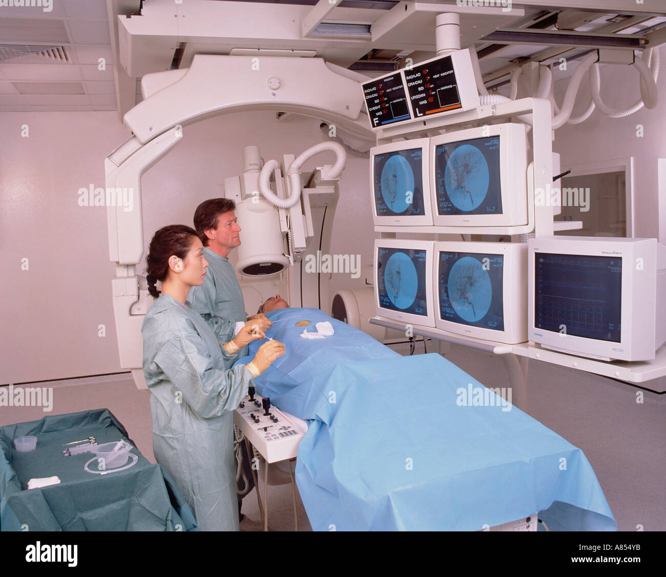 Arzt und Krankenschwester mit Patienten im Krankenhaus Angiographie Scan Zimmer. Stockfoto