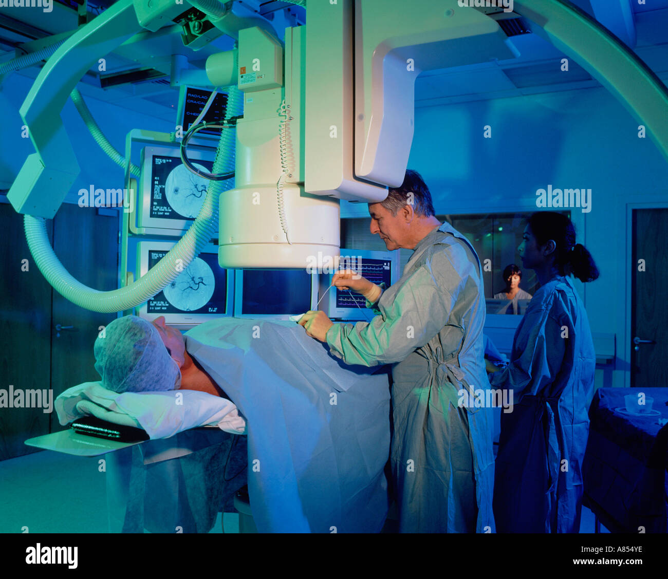 Arzt und Krankenschwester mit Patienten im Krankenhaus Angiographie Scan Zimmer. Stockfoto