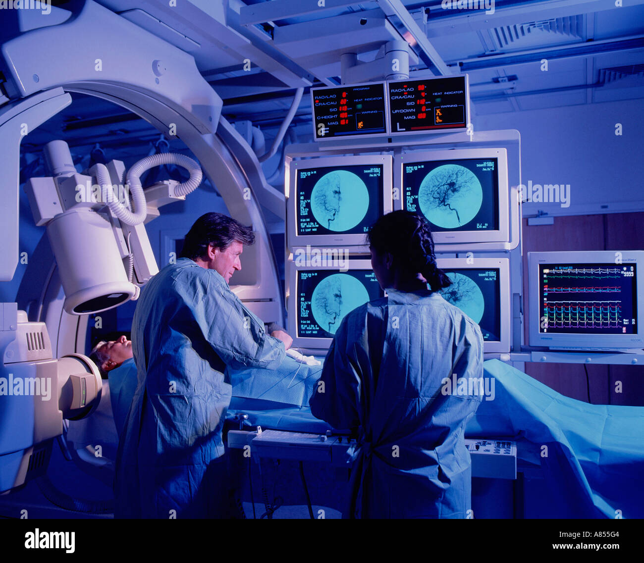 Arzt und Krankenschwester mit Patienten im Krankenhaus Angiographie Scan Zimmer. Stockfoto