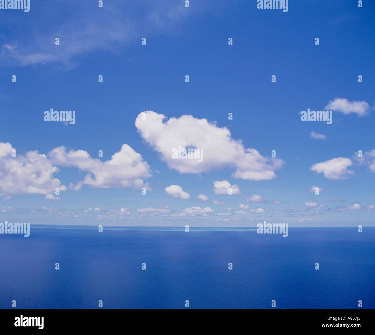 Australien. Queensland. Great Barrier Reef. Seelandschaft. Sonnigen blauen Himmel mit flauschigen weißen Wolken über Blauwasser Horizont Stockfoto