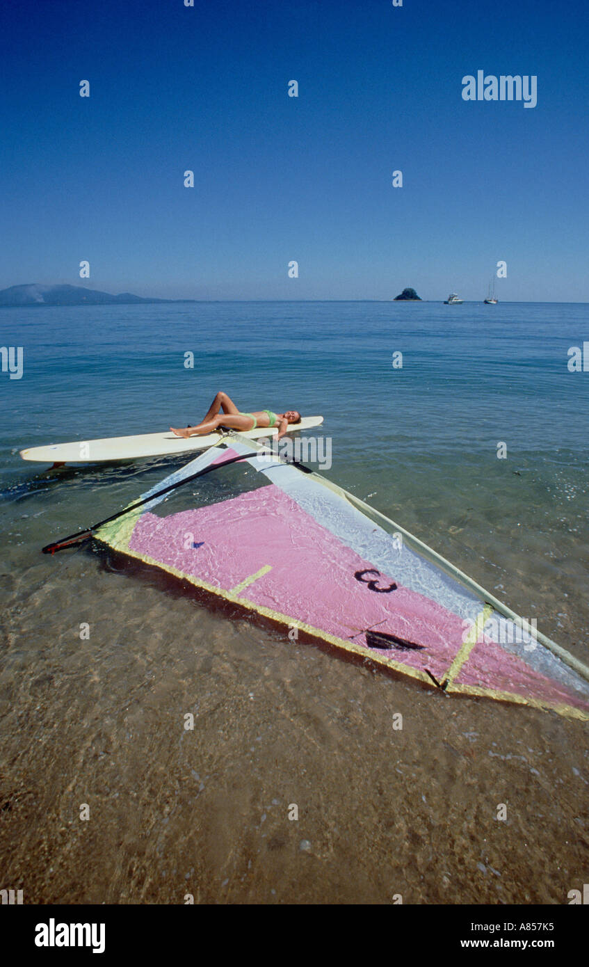 Australien. Queensland. Dunk Island. Junge Frau liegend auf einem Surfbrett. Stockfoto