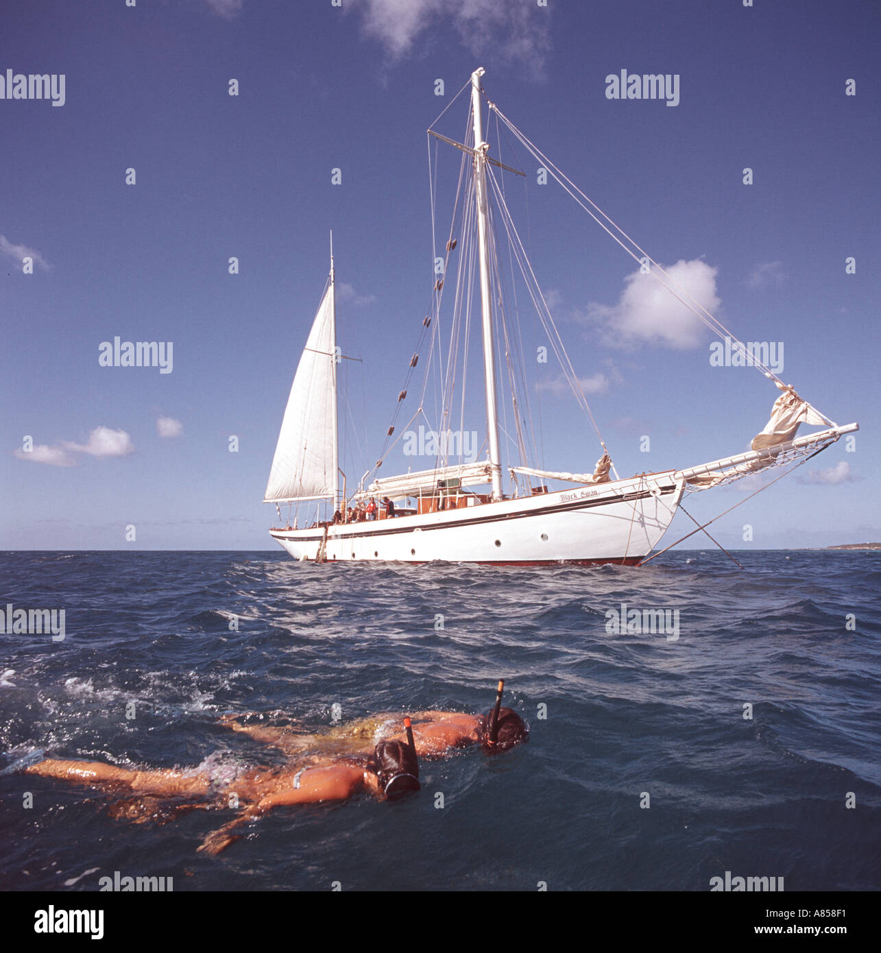 paar Schnorcheln im Meer mit Segelyacht verankert in Ferne Stockfoto