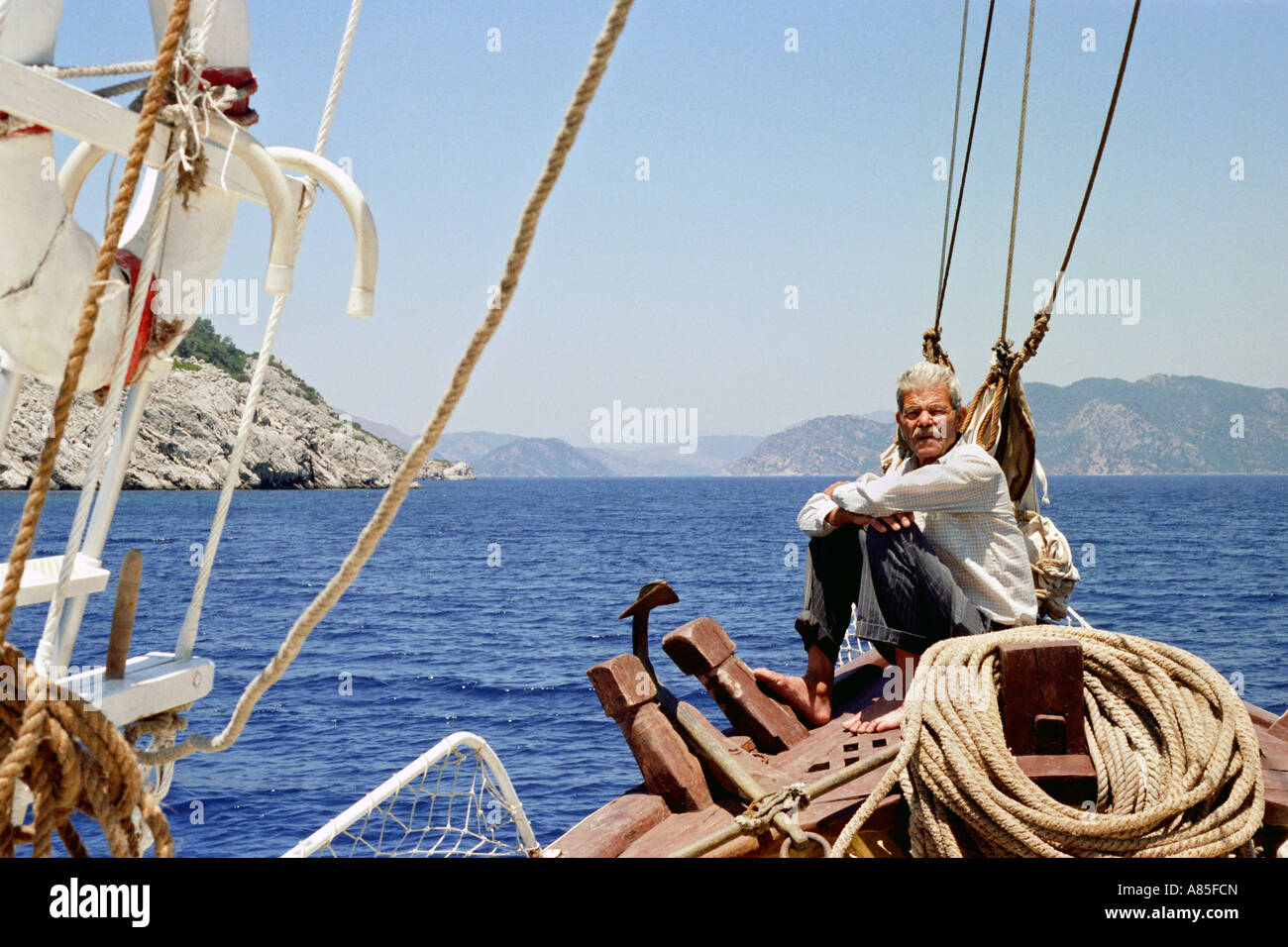 Alte griechische Matrose auf einem lokalen Fischerboot vor der Küste der Türkei ausgehende von Rhodos, Dodekanes, Griechenland Stockfoto